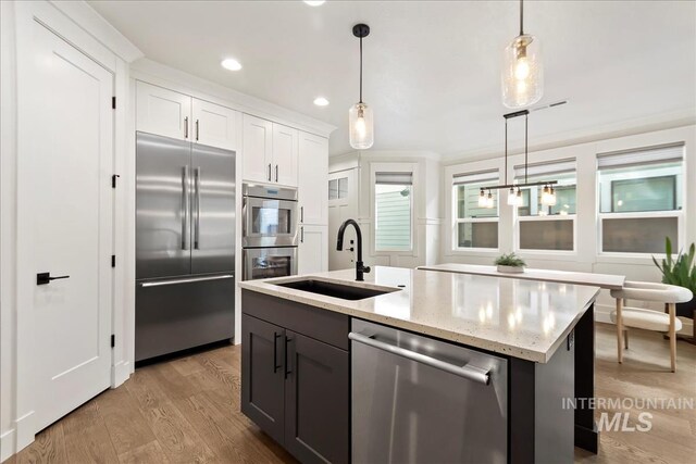 3268 S Sedgebrook Ln, Eagle, ID 83616 - kitchen featuring a sink, appliances with stainless steel finishes, light wood-style floors, and pendant lighting