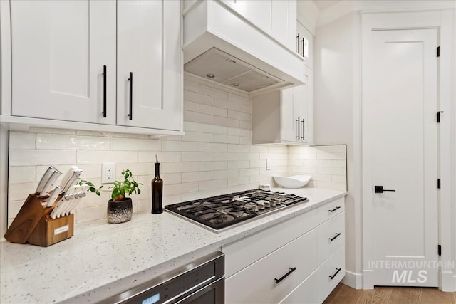 3268 S Sedgebrook Ln, Eagle, ID 83616 - kitchen featuring white cabinetry, stainless steel gas cooktop, custom exhaust hood, and decorative backsplash