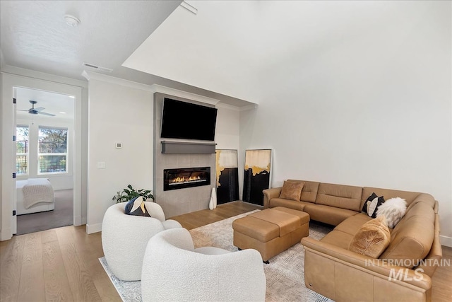 3268 S Sedgebrook Ln, Eagle, ID 83616 - living room with crown molding, baseboards, light wood finished floors, visible vents, and a tiled fireplace