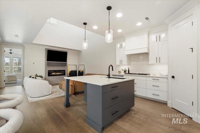 3268 S Sedgebrook Ln, Eagle, ID 83616 - kitchen featuring a sink, wood finished floors, gray cabinetry, open floor plan, and white cabinets