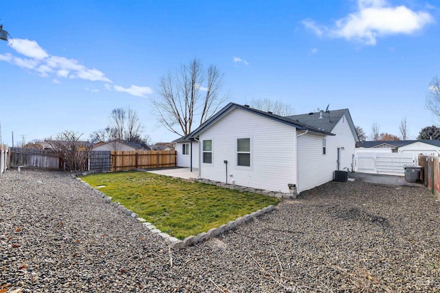 view of side of property with central AC, a lawn, a fenced backyard, a patio, and a gate