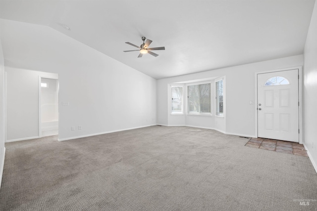 unfurnished living room with carpet, visible vents, baseboards, lofted ceiling, and ceiling fan