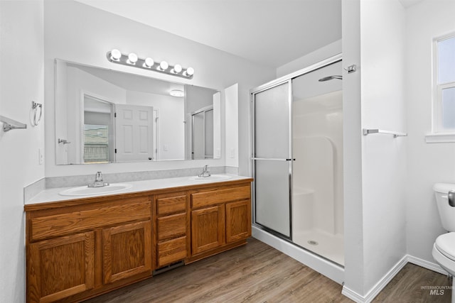 full bathroom featuring a sink, wood finished floors, toilet, and a stall shower