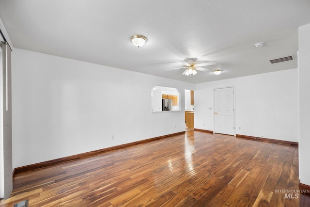 empty room featuring baseboards, visible vents, ceiling fan, and hardwood / wood-style floors