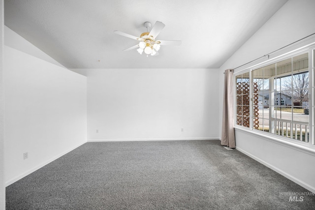 carpeted empty room featuring lofted ceiling, ceiling fan, and baseboards