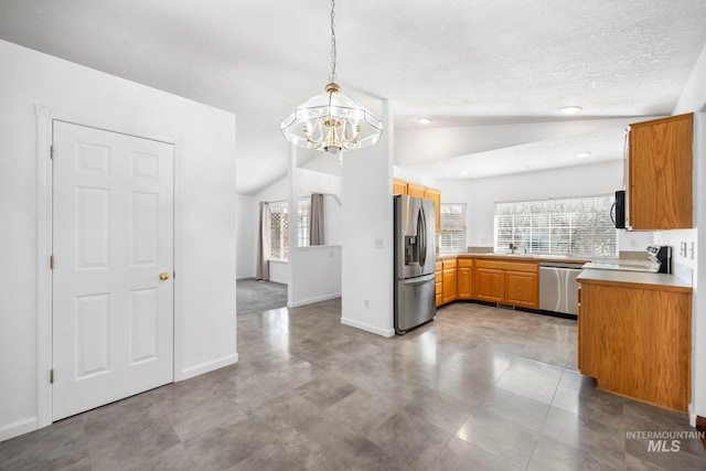 kitchen with lofted ceiling, light countertops, appliances with stainless steel finishes, and plenty of natural light