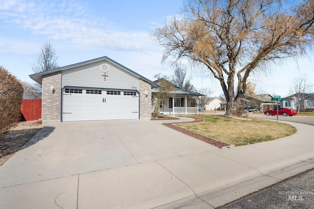 ranch-style house featuring an attached garage, brick siding, fence, concrete driveway, and a front yard