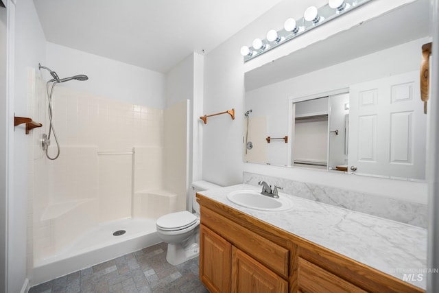 bathroom featuring vanity, walk in shower, and toilet