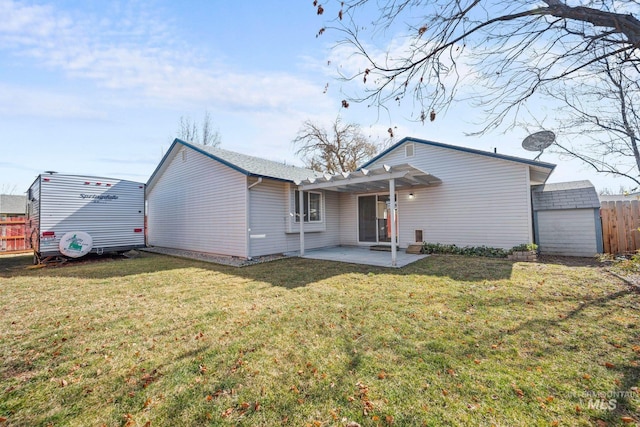 back of house featuring a yard, an outbuilding, a patio, and fence