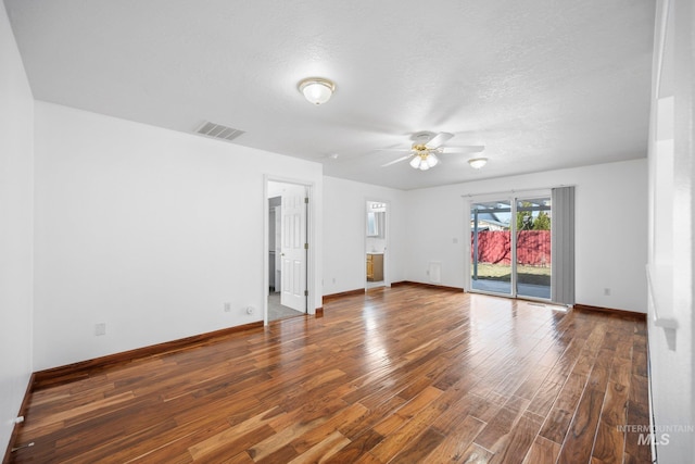 empty room featuring visible vents, ceiling fan, a textured ceiling, wood finished floors, and baseboards