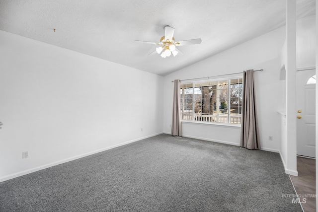 carpeted empty room featuring a ceiling fan, vaulted ceiling, a textured ceiling, and baseboards