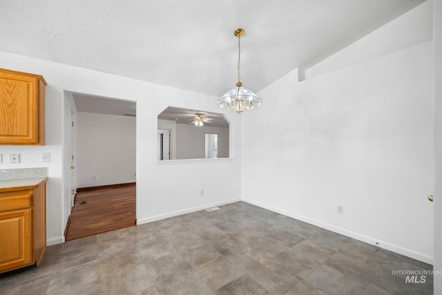 unfurnished dining area with an inviting chandelier, baseboards, and vaulted ceiling