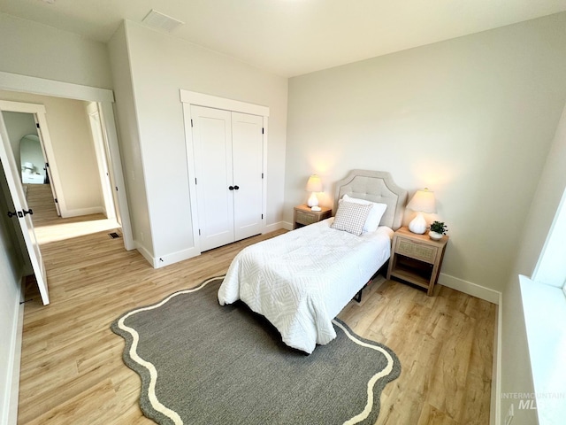 bedroom featuring light wood-type flooring and a closet