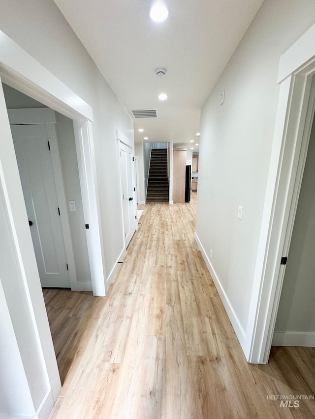 corridor with light hardwood / wood-style floors