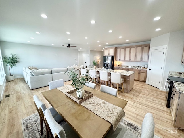dining area with ceiling fan and light hardwood / wood-style flooring