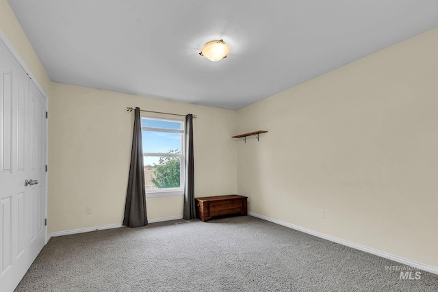 carpeted spare room featuring baseboards