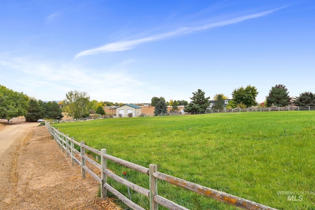 view of yard with fence and a rural view