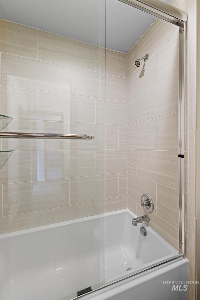 bathroom with bath / shower combo with glass door