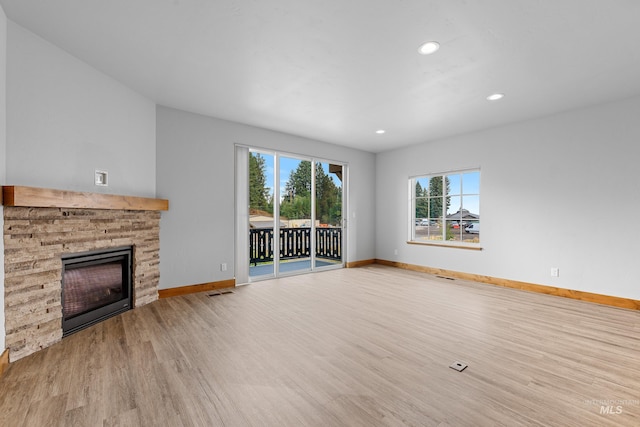 unfurnished living room with a fireplace and light hardwood / wood-style floors