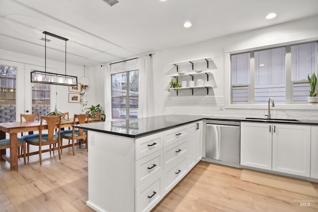 kitchen featuring kitchen peninsula, dishwasher, pendant lighting, white cabinets, and sink