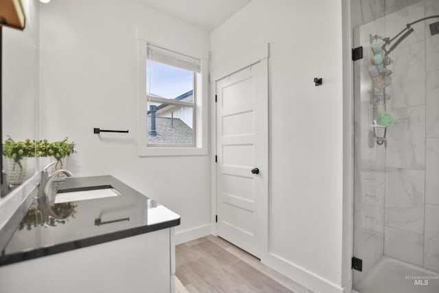 bathroom featuring an enclosed shower, vanity, and hardwood / wood-style floors