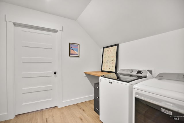 laundry area with light hardwood / wood-style flooring and washing machine and clothes dryer