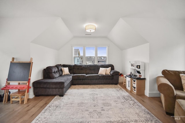 living room featuring vaulted ceiling and wood-type flooring