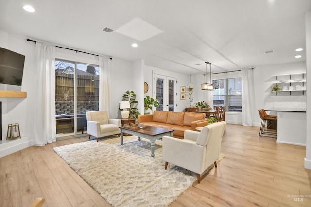 living room with french doors and light wood-type flooring