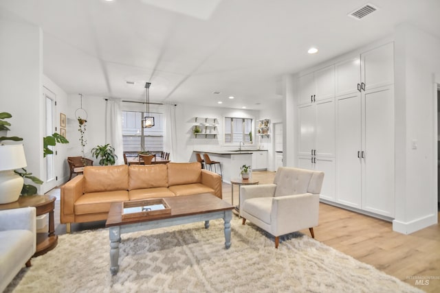 living room with sink and light hardwood / wood-style flooring