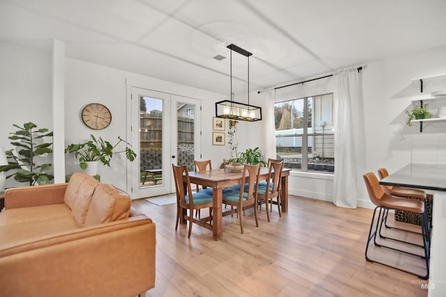 dining space with light hardwood / wood-style floors and french doors