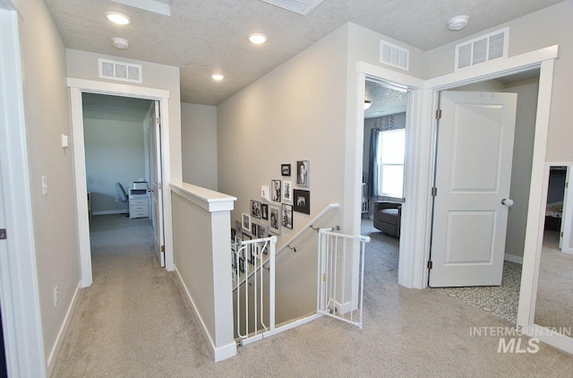 10382 Scout Ridge St, Nampa, ID 83687 - corridor with an upstairs landing, light colored carpet, baseboards, a textured ceiling, and recessed lighting