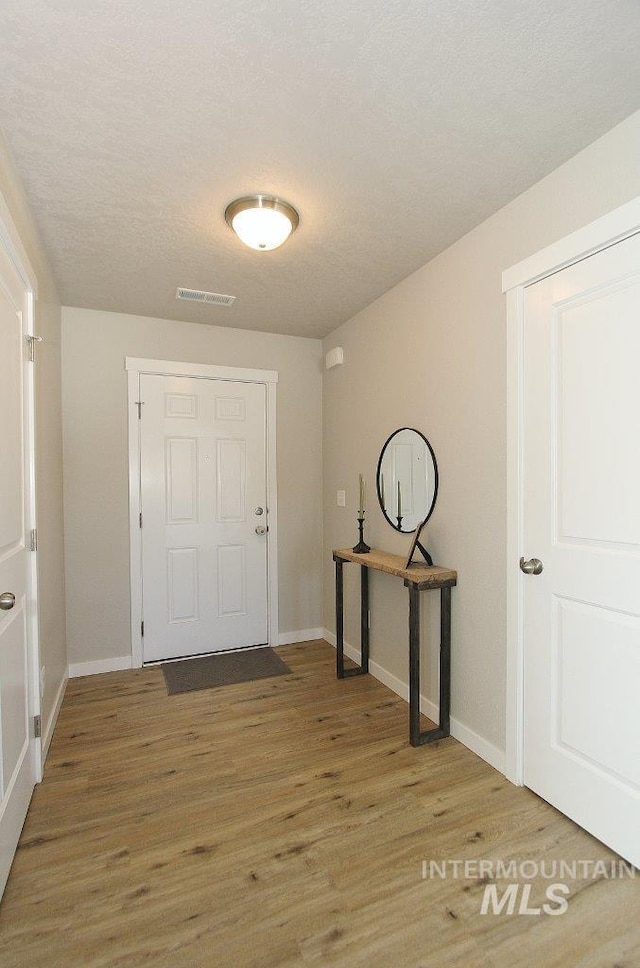 10382 Scout Ridge St, Nampa, ID 83687 - foyer entrance featuring light wood-type flooring, baseboards, and a textured ceiling