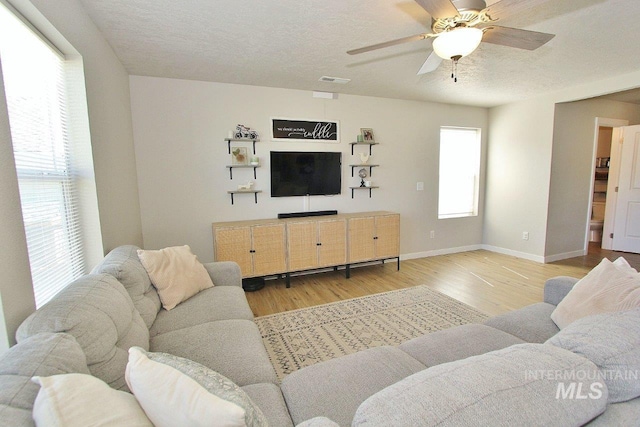 10382 Scout Ridge St, Nampa, ID 83687 - living area featuring light wood-style floors, baseboards, a ceiling fan, and a textured ceiling