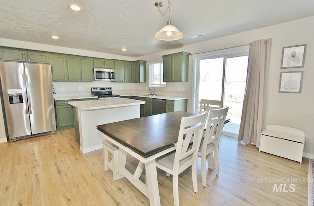 10382 Scout Ridge St, Nampa, ID 83687 - kitchen featuring appliances with stainless steel finishes, green cabinetry, light countertops, light wood-type flooring, and recessed lighting