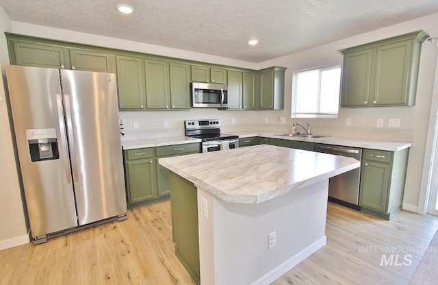 10382 Scout Ridge St, Nampa, ID 83687 - kitchen with stainless steel appliances, green cabinets, a sink, light countertops, and recessed lighting