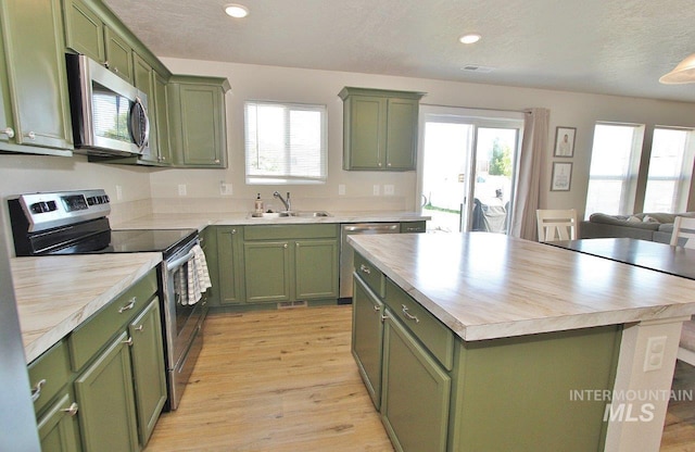10382 Scout Ridge St, Nampa, ID 83687 - kitchen with green cabinetry, appliances with stainless steel finishes, a sink, a textured ceiling, and recessed lighting