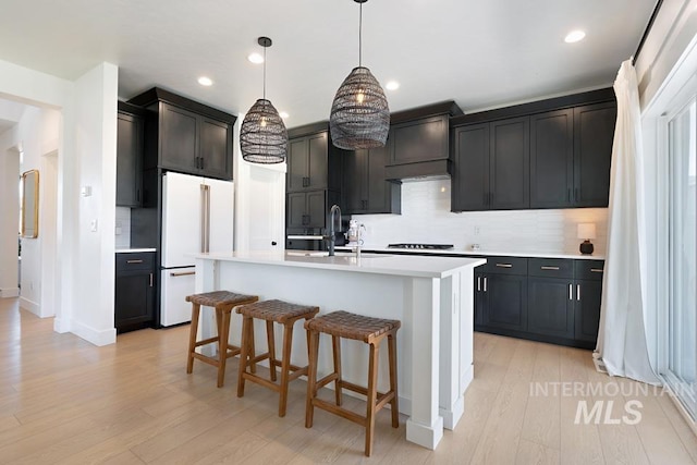 12524 W Shortcreek, Star, ID 83669 - kitchen with freestanding refrigerator, backsplash, light countertops, light wood-type flooring, and recessed lighting