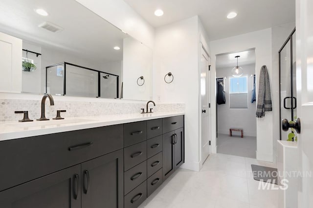 12524 W Shortcreek, Star, ID 83669 - bathroom with a stall shower, double vanity, backsplash, recessed lighting, and a walk in closet