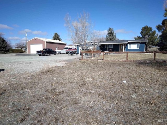 ranch-style home with a garage and an outbuilding