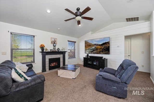 23 N 950 E, Declo, ID 83323 - carpeted living room featuring a ceiling fan, visible vents, a fireplace with flush hearth, vaulted ceiling, and baseboards