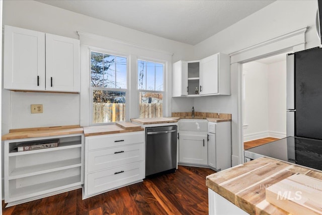 kitchen with dark wood-type flooring, butcher block countertops, a sink, white cabinetry, and stainless steel appliances