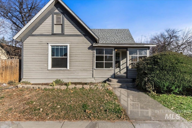 view of front of house featuring fence and a shingled roof