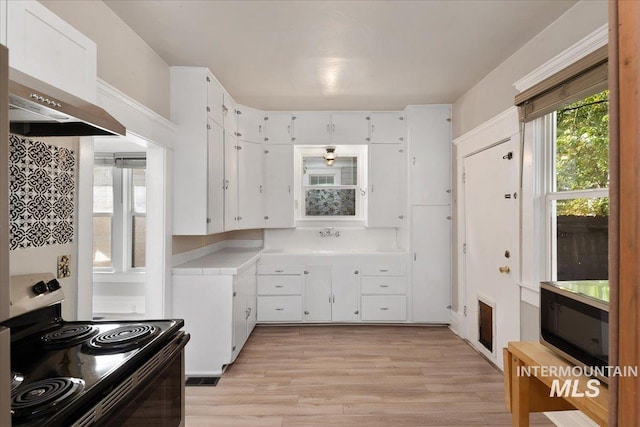 kitchen with visible vents, light countertops, electric range oven, light wood-style flooring, and white cabinets