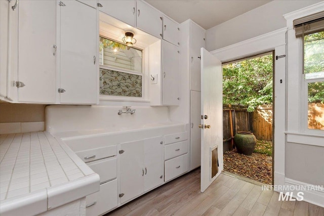 bathroom with wood finished floors, baseboards, and a sink