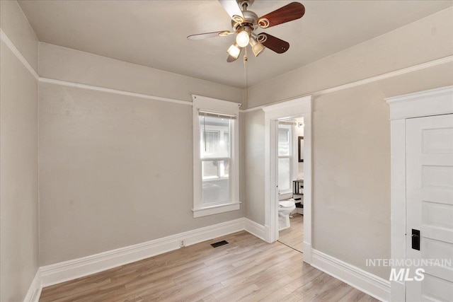 unfurnished bedroom featuring visible vents, a ceiling fan, connected bathroom, light wood-style floors, and baseboards