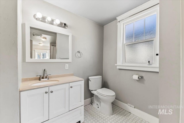 bathroom featuring vanity, toilet, and baseboards