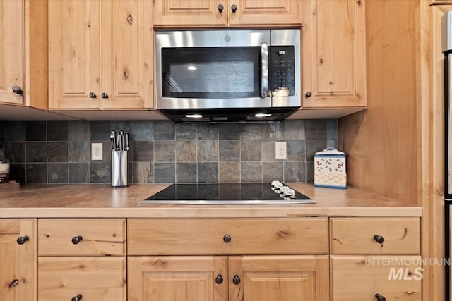23 Waterline Ln, Cascade, ID 83611 - kitchen featuring stainless steel microwave, light brown cabinetry, backsplash, black electric cooktop, and light countertops