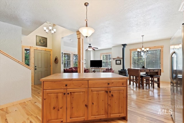 23 Waterline Ln, Cascade, ID 83611 - kitchen featuring a chandelier, stainless steel refrigerator, a textured ceiling, light wood-type flooring, and a center island