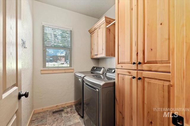 23 Waterline Ln, Cascade, ID 83611 - laundry area featuring cabinet space, independent washer and dryer, and stone finish flooring