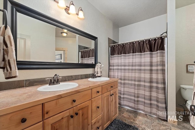 23 Waterline Ln, Cascade, ID 83611 - bathroom with double vanity, a textured wall, a shower with shower curtain, a textured ceiling, and stone finish flooring